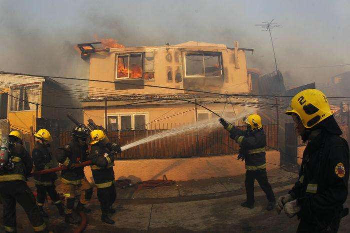 CH01. VALPARAISO (CHILE), 02/01/2017.- Personal de bomberos combate un incendio forestal en el sector de Playa Ancha en la ciudad de Valparaíso (Chile) hoy, 2 de enero de 2016, que afectó a viviendas y vecinos del sector. Un incendio forestal que estalló hoy en la parte alta del puerto chileno de Valparaíso llevó a las autoridades a declarar alerta roja en la ciudad y a disponer la evacuación preventiva de unas 25 viviendas próximas al foco de fuego, informaron fuentes oficiales.