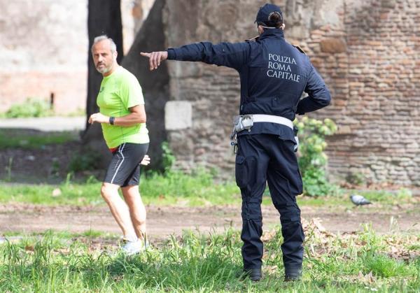Policía italiano insta a un corredor a irse a su casa. Roma 21 de marzo